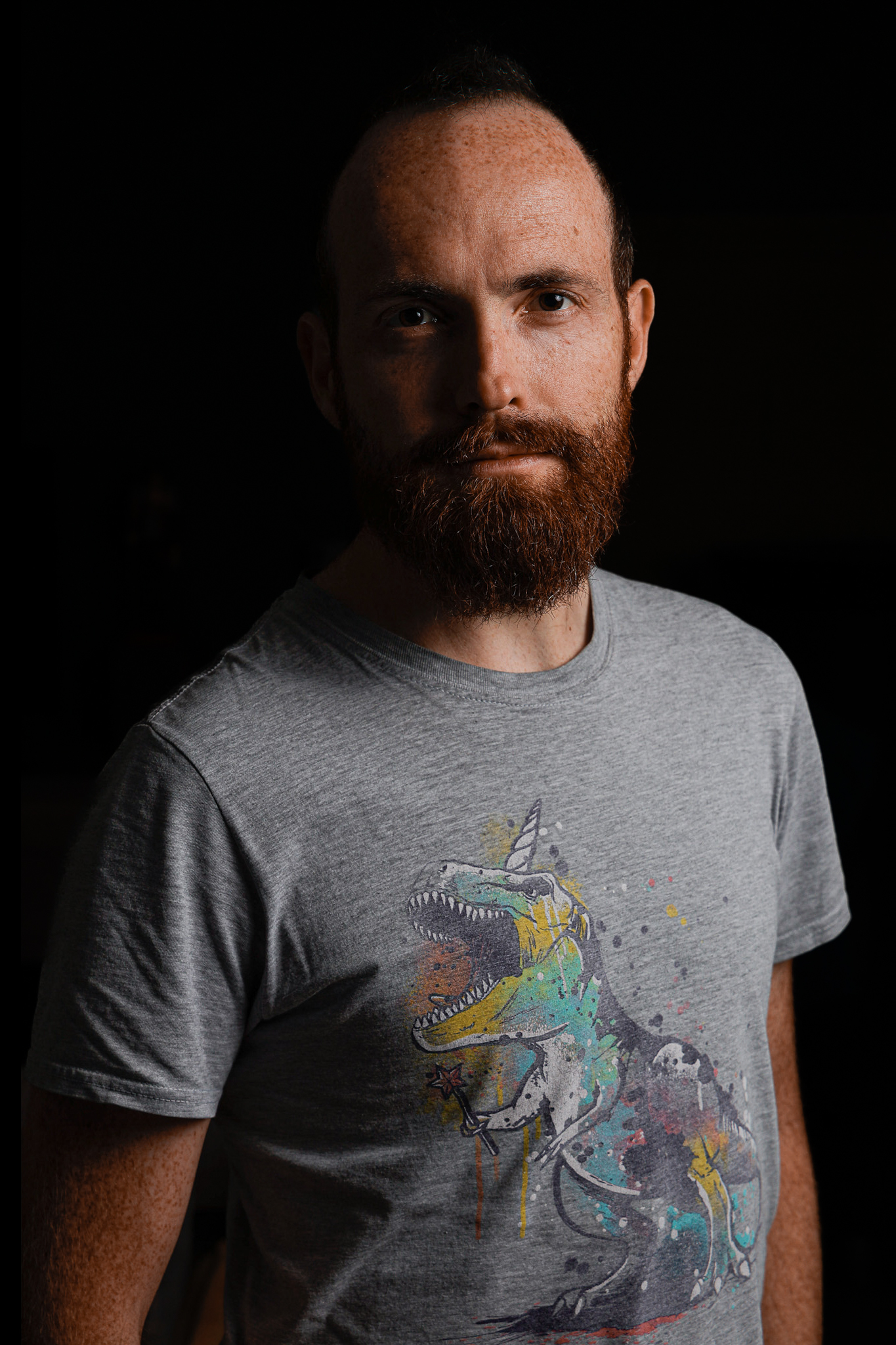 Photo de Vincent avec un Tshirt représentant un tyranosaure licorne.
